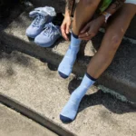 Athlete putting on light blue custom knitted logo socks before running