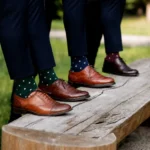 Men wearing custom crew dress socks in green, navy, and burgundy polka-dot designs with leather shoes.