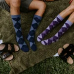 Blue and purple argyle over the calf dress socks worn during an outdoor picnic.