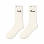 White custom Bride ruffle socks with black scalloped cuffs and embroidered Bride lettering.