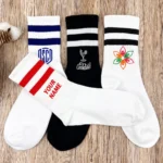 Four custom crew socks with embroidered logos, striped cuffs and personalized name options.