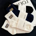 Black, navy, and white crew socks with custom embroidered logos and packaging